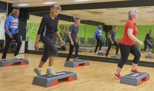 Two men and two women in a stepping class at a gym