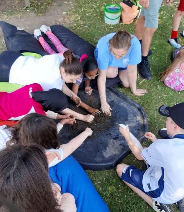 Group of children at outdoor activity playing with soil