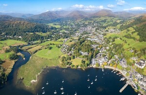 Aerial view of a lake, fields and woods