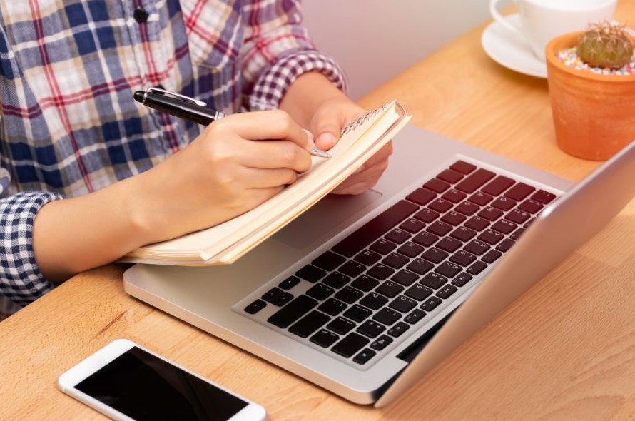 Man taking notes from an online course