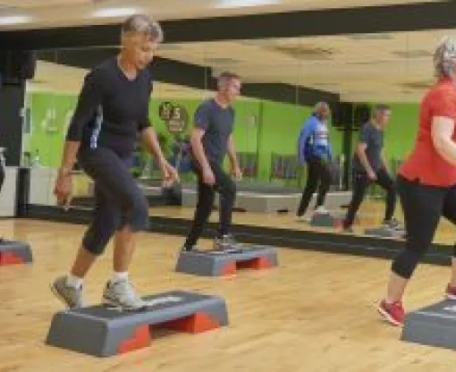 Two men and two women in a stepping class at a gym