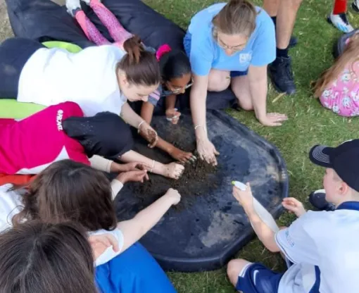 Group of children at outdoor activity playing with soil