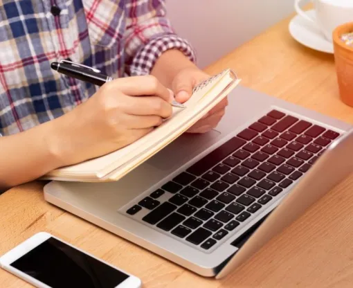 Man taking notes from an online course