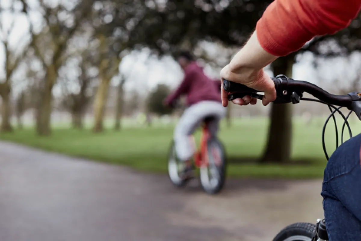 Two people on bikes cycling through a park