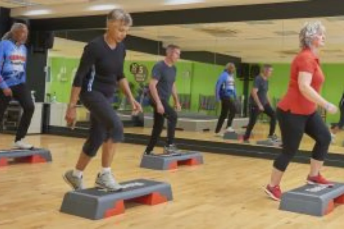 Two men and two women in a stepping class at a gym