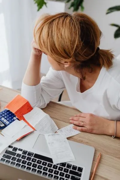 Women with head in hands surrounded by bills